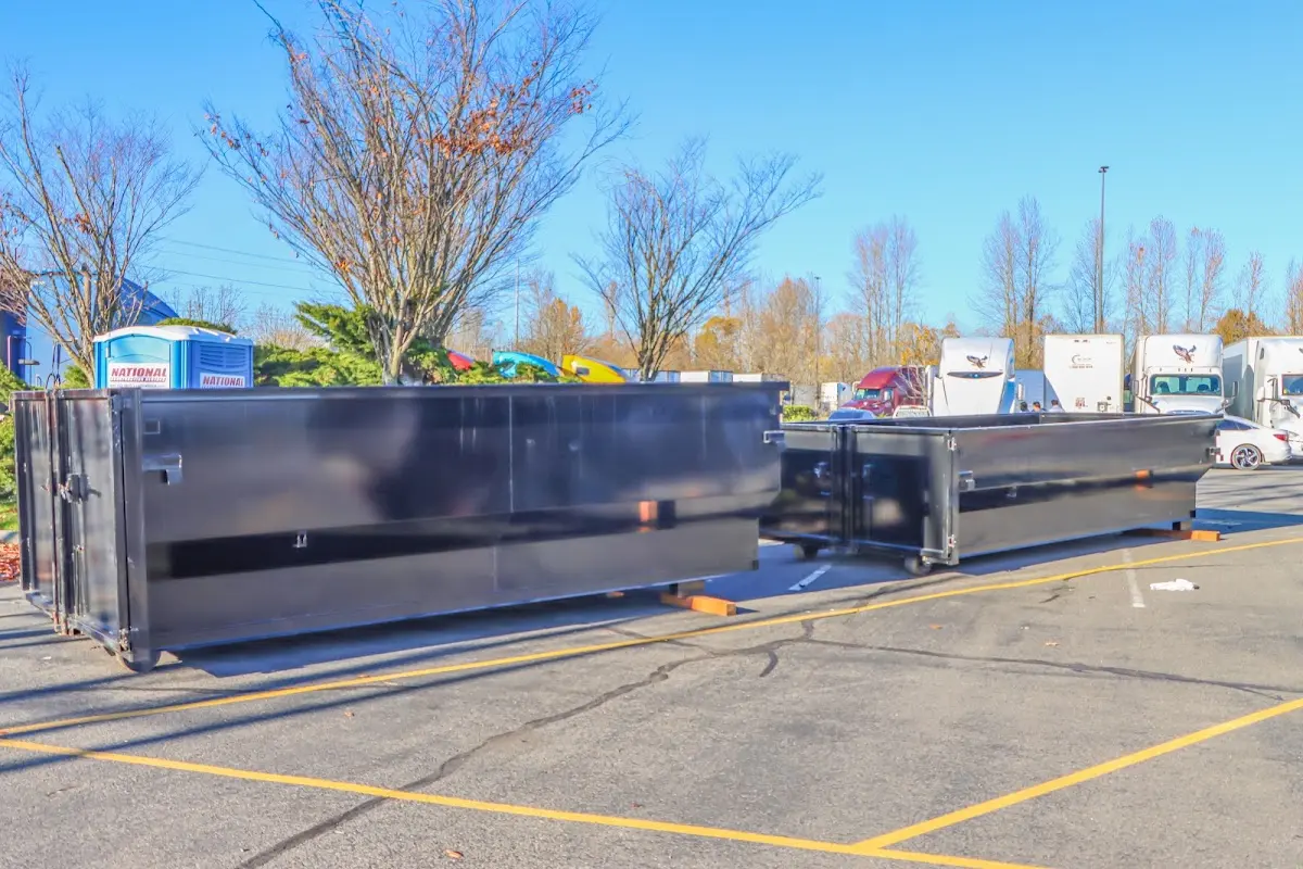 Professional dumpster rental service with roll-off container on residential driveway in Fruit Heights